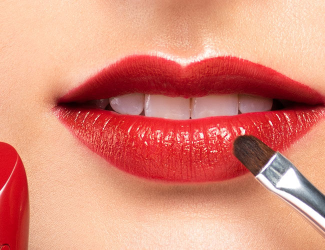 Ein Lippenstift wird mit Hilfe eines Pinsels aufgetragen
