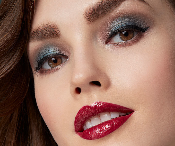 Ein Model mit einem starken Augen-Make-up und rot geschminkten Lippen