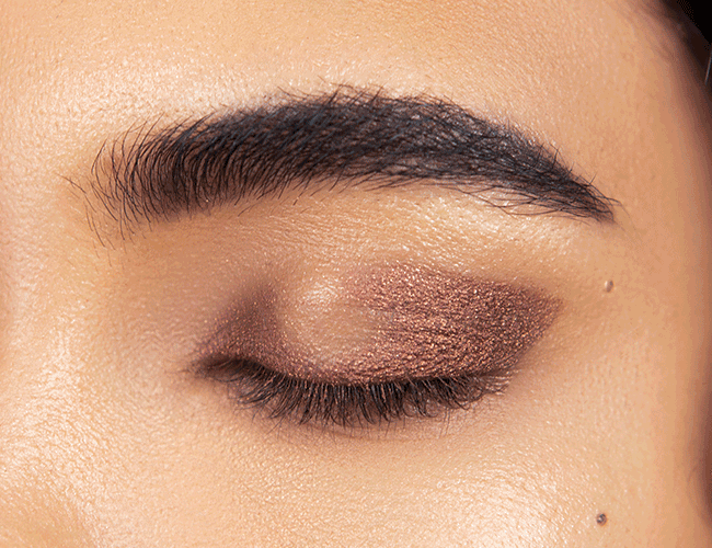 A brown eye shadow is applied on the movable eyelid  