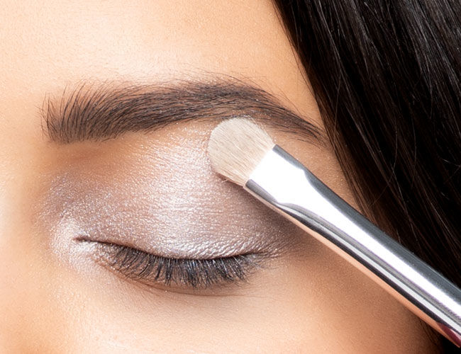 A light-colored eyeshadow is applied to the lid